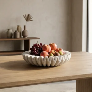 Artisanal scalloped stone fruit bowl filled with fresh grapes, figs, and apples, showcasing its use as a luxury centerpiece for kitchen or dining decor.